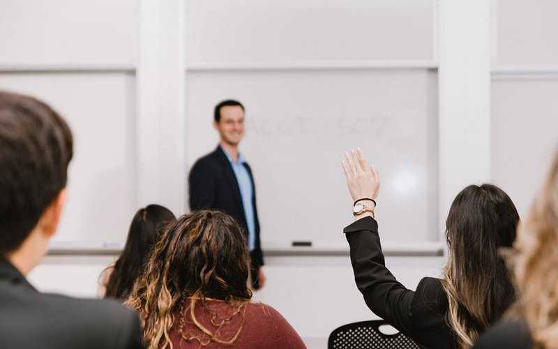 Accounting students raise their hands during a lecture.