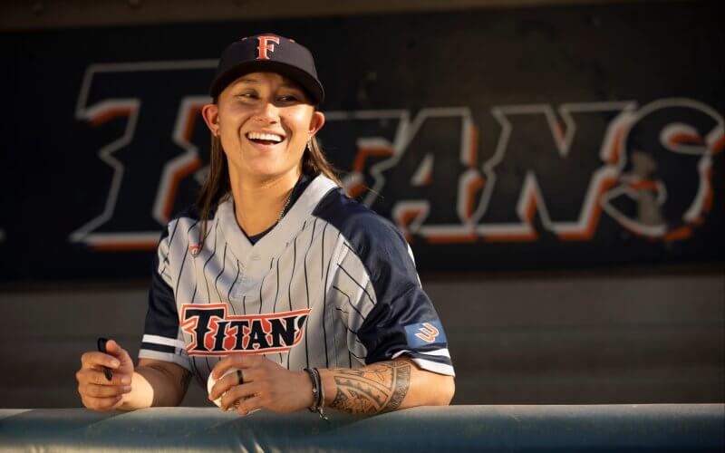 Kelsie Whitmore stands in the dugout at Goodwin Field.