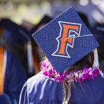Student with commencement cap that features Fullerton "F" logo