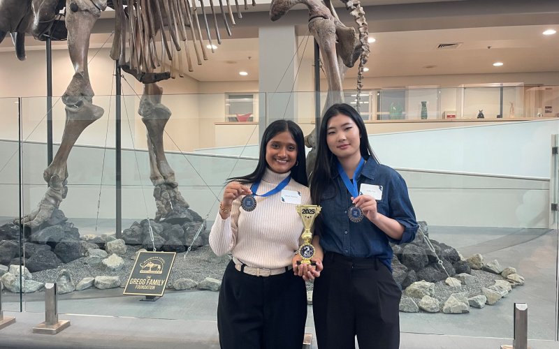 Dhara Panchal and Julie Yun hold second-place medals at the 2025 Titan Fast Pitch competition.