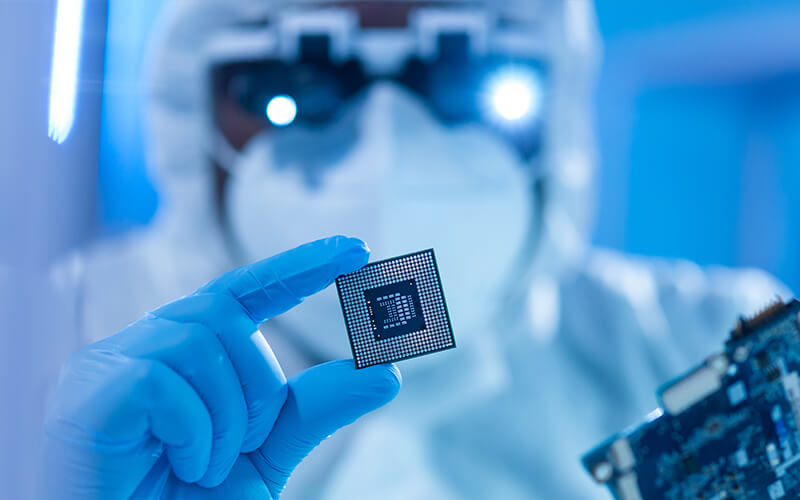 Photo of a worker developing microelectronics and processors in a lab