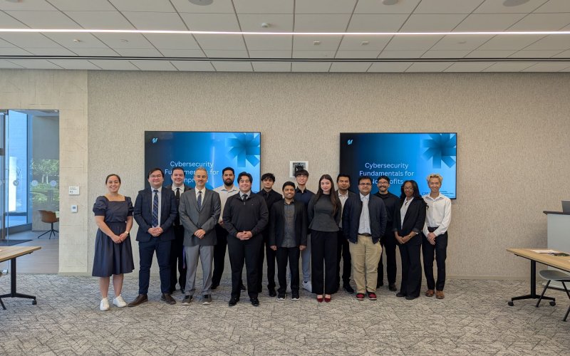 Students from the OC Cyber Clinic pose with a Farmers & Merchants Bank supporter in a conference room.