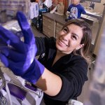 Nursing student Sophia Santana hangs a saline bag.