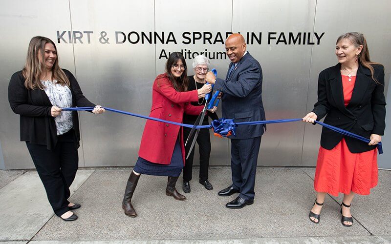 Donna Spradlin and CSUF leaders cut a ribbon at the naming ceremony for the Kirt and Donna Spradlin Family Auditorium