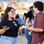 ASI student employee talks to a student on Titan Walk.