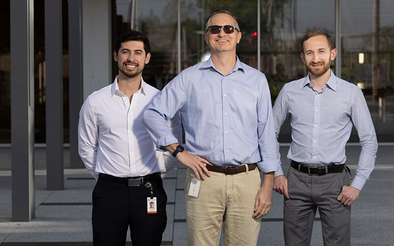 Alums and Edwards Lifesciences employees Greg Wright, center, Ryan Kean, left, and Nick Herrera outside of Edwards Lifesciences, medical device company