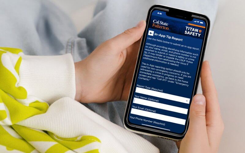 A person holds a phone with the TitanSafety app open on the screen.