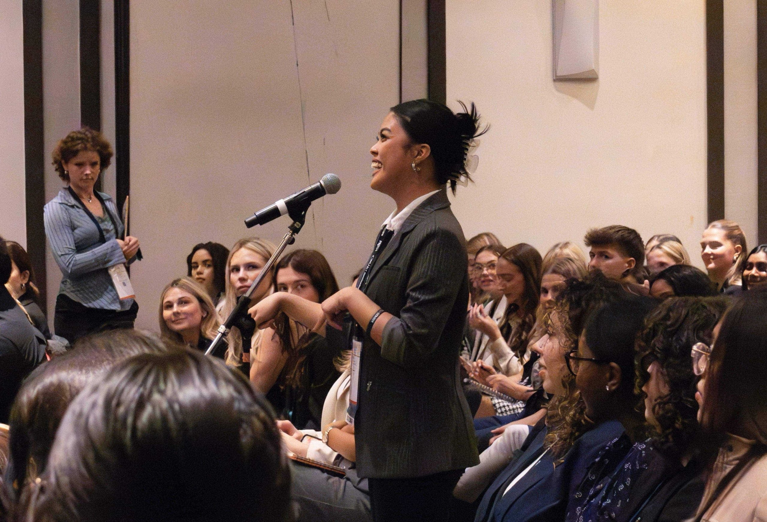 A student speaking into a microphone at the PRSSA National Conference.