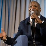 Terry Crews talks into a microphone on stage in the Titan Student Union.