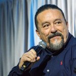 Mister Cartoon talks into a microphone in the Titan Student Union Portola Pavilion