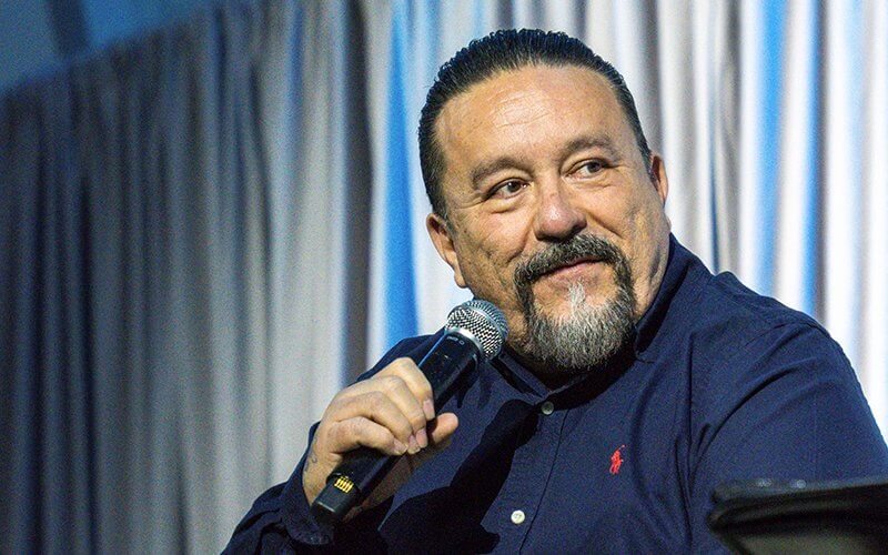 Mister Cartoon talks into a microphone in the Titan Student Union Portola Pavilion