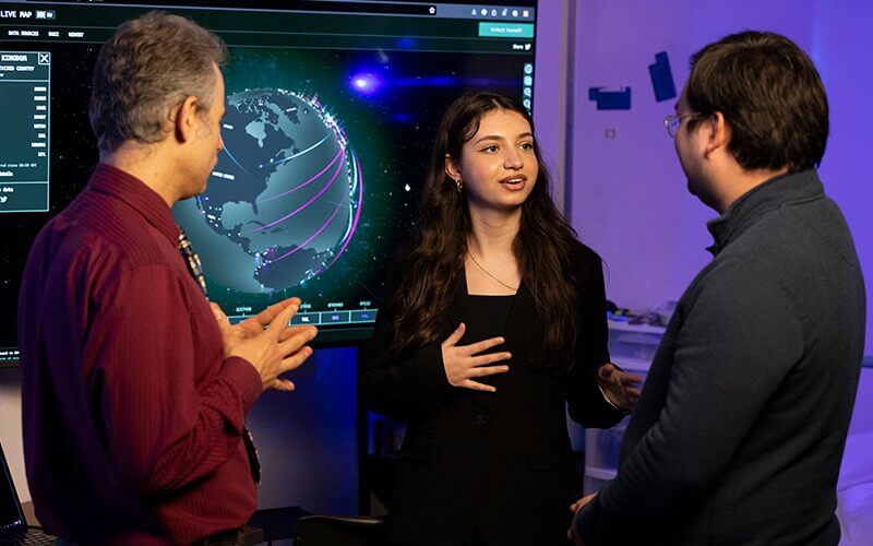 Student Maha AlJaffan, center, talks with Mikhail Gofman, left, and Michael Franklin, right.