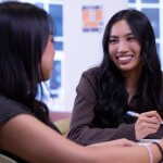 Dayna Nguyen works with another student in the Business Honors Program lounge.
