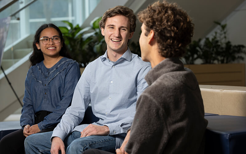 Devin Gruenthal, president of CSUF's Volunteer Income Tax Assistance Program, speaks with two students in the College of Business and Economics building