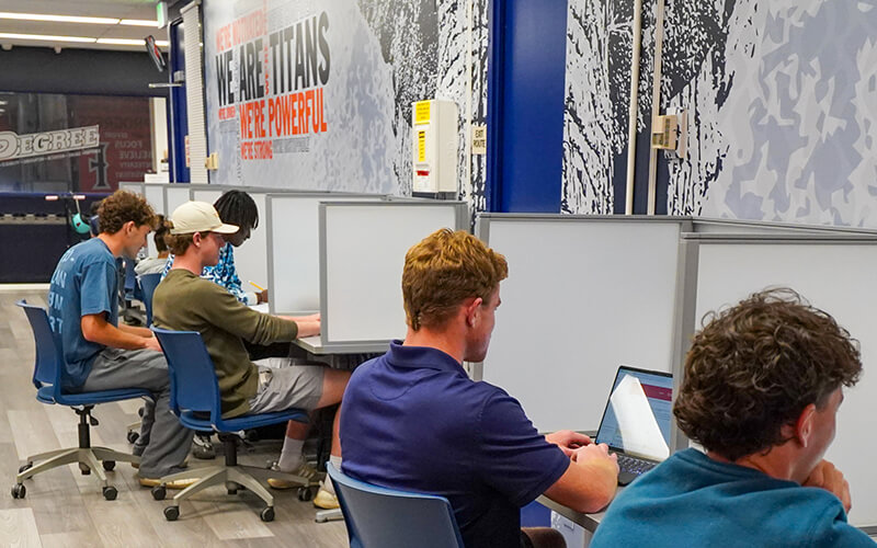 Student-athletes work on computers in the Athletics Academic Services Learning Center
