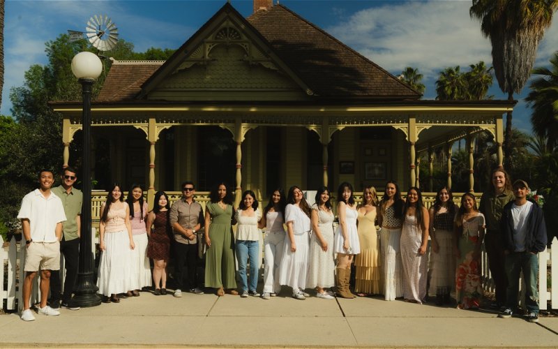 CSUF students stand in front of the Heritage House in the Arboretum and Botanical Garden at Cal State Fullerton