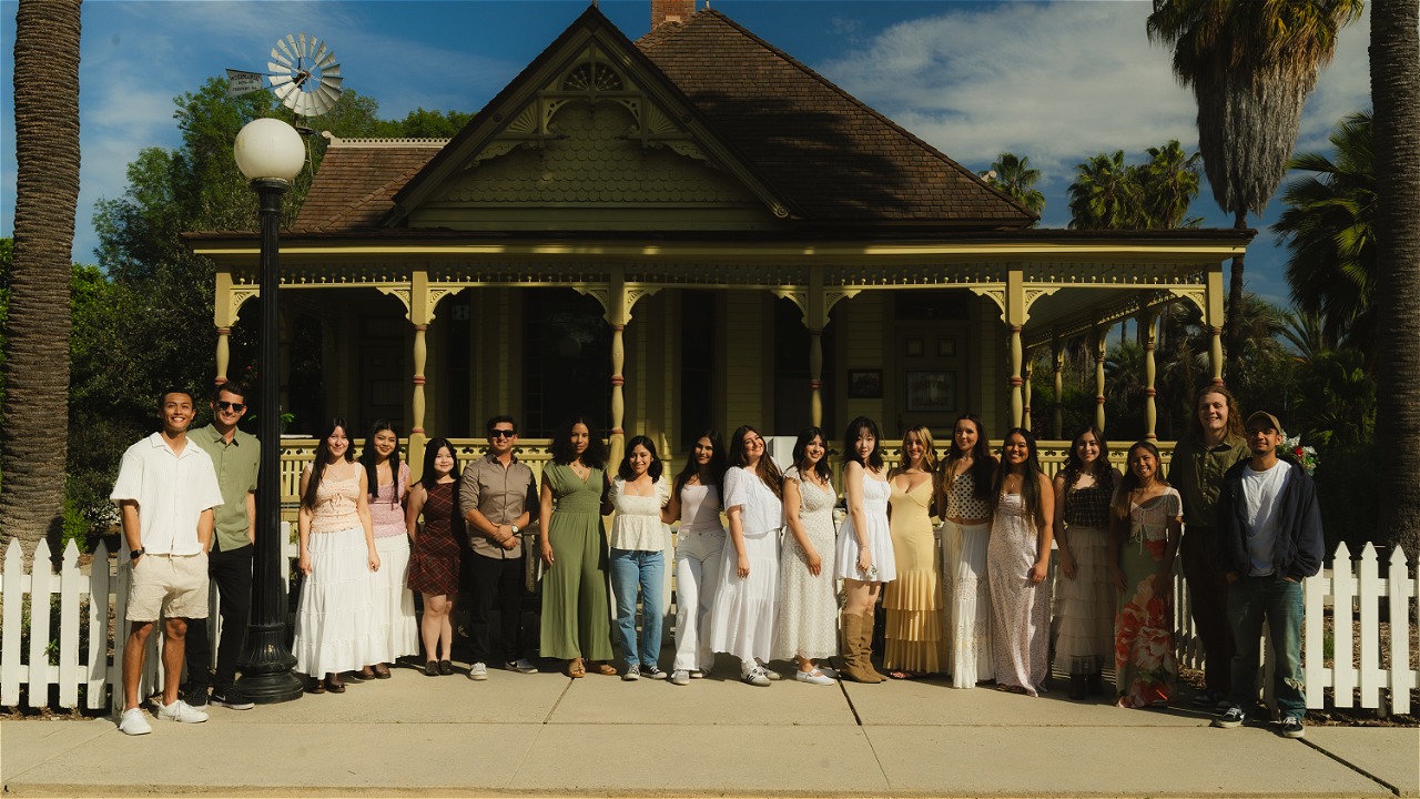 CSUF students stand in front of the Heritage House in the Arboretum and Botanical Garden at Cal State Fullerton