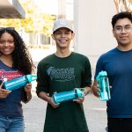 Students Jasmine Cerasuolo, Juan Rodriguez and Luis Carpio hold Amazon mentorship program water bottles