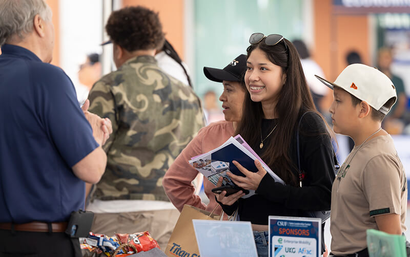 Estrella Regalado speaks with Brad Anderson of the College of Business and Economics at the college resource fair.