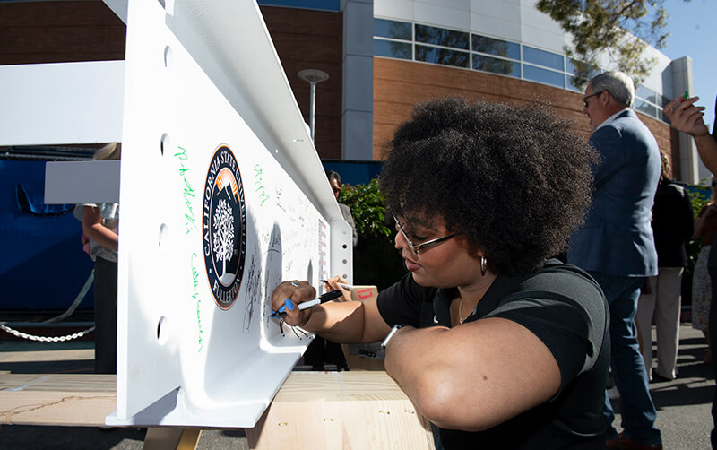 Taylor Livingston signs a construction beam for Landmark Hall.
