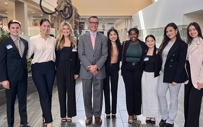 Jake Beniflah, lecturer in marketing, poses for a group photo with students