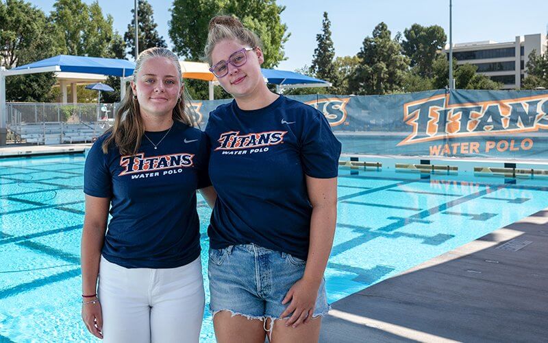 Renske and Lotte Boxsem stand by the pool in the Titan Aquatics Center
