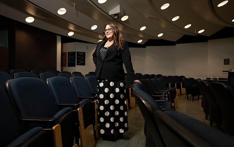 Sociology and philosophy grad Nichole Gideon poses in classroom