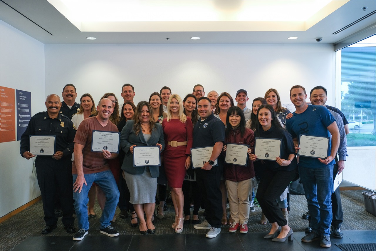A group of students pose for a photo, holding certificates.