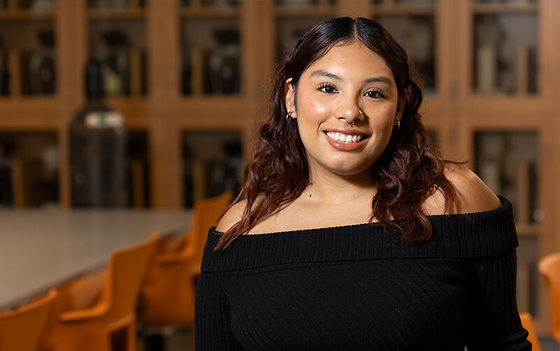 Biological science student Lexys Salcido stands in a biology classroom.