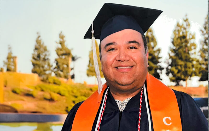 Class of 2026 grad Osvaldo Flores in graduation regalia at CSUF's Commencement 2026
