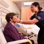 A nursing student checks the vitals of a patient sitting in the Nursing Simulation Lab.