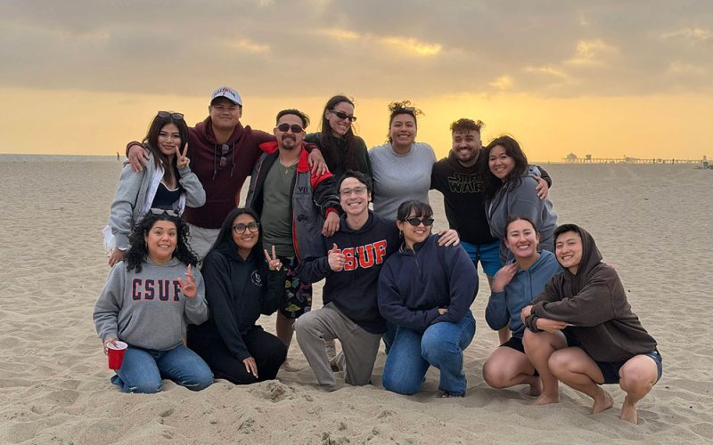 Students in The Herd club pose for a group photo at the beach.