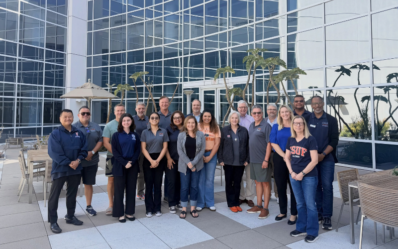 CSUF Alumni Association board members pose for a group photo outside of the College of Business and Economics building.