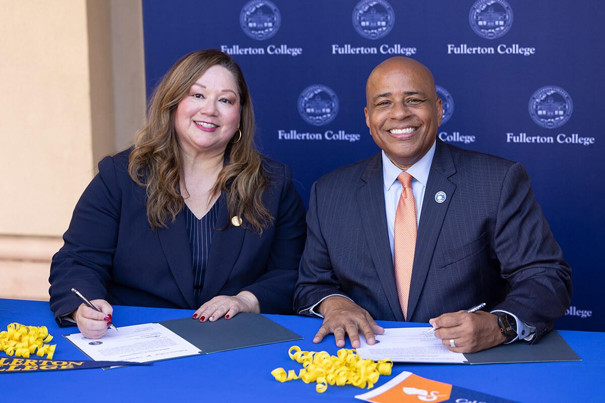 Cynthia Olivo, president of Fullerton College, and Ronald S. Rochon, president of CSUF, sign a MOU.