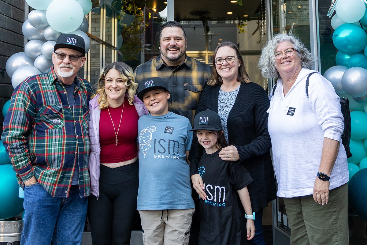 CSUF alum Ian McCall and his family stand outside ISM Brewing to celebrate its grand opening.