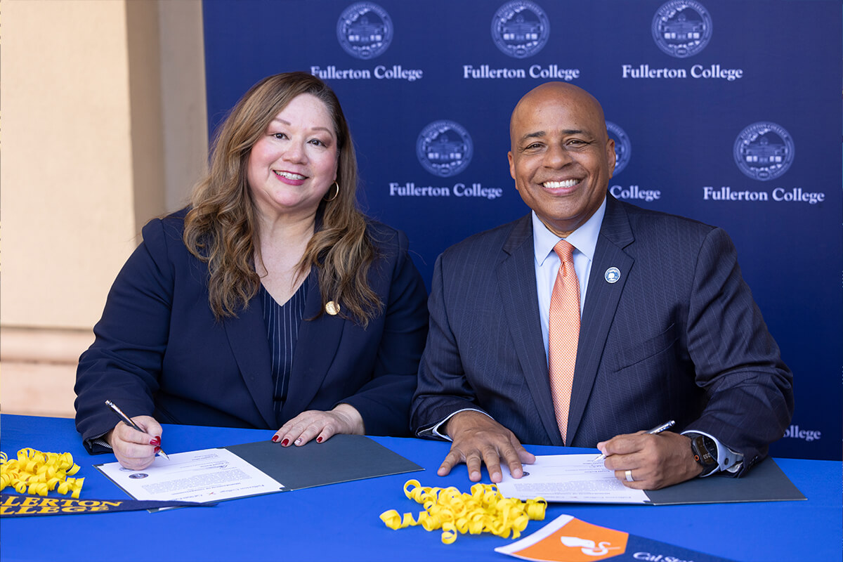 Cynthia Olivo, president of Fullerton College, and Ronald S. Rochon, president of CSUF, sign a MOU.
