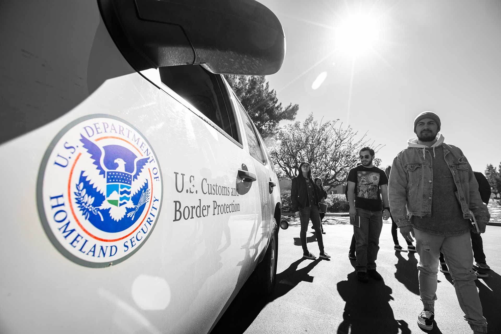 Student looks at Border Patrol vehicle with large Homeland Security emblem on it