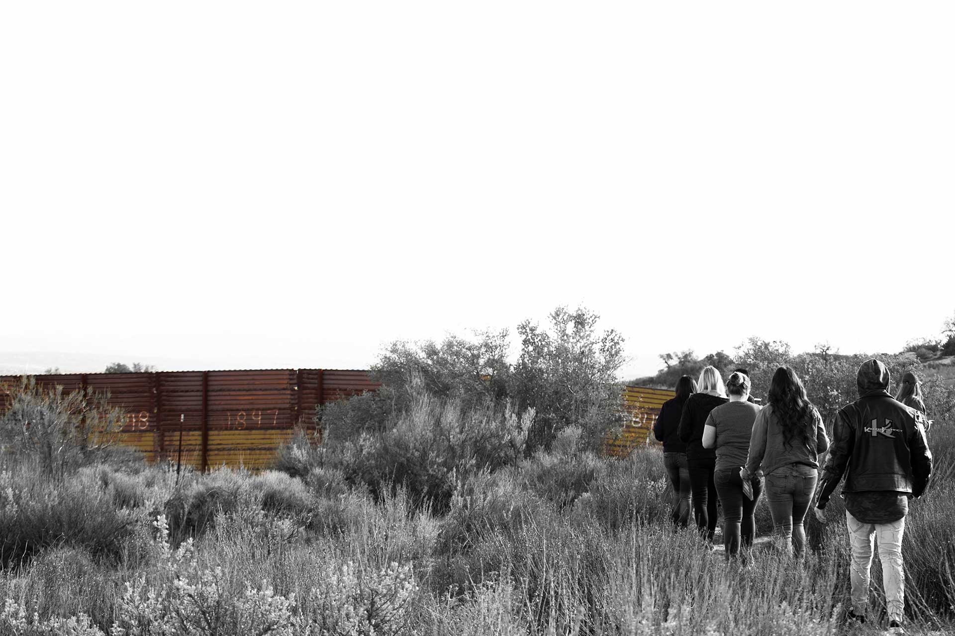 CSUF Students walk through the desert towards the border fence.